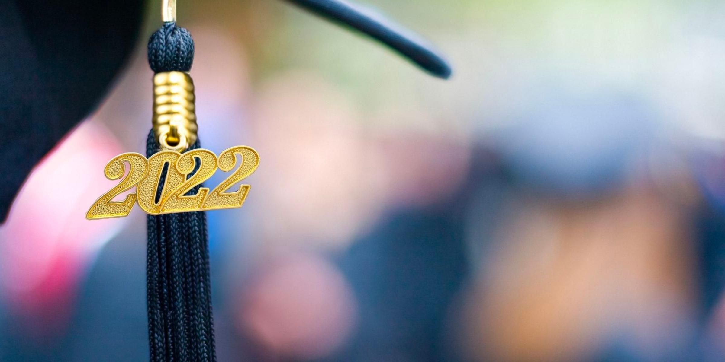 closeup of a tassel on a dark blue graduation cap with a golden charm that says 2022